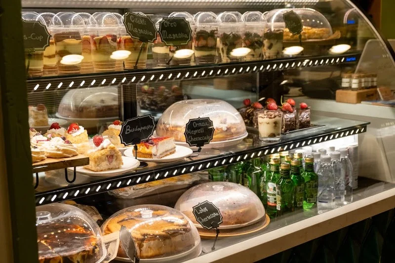 Renkli pastalar ve tatlıların sergilendiği modern pastane vitrine