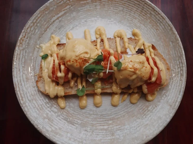 Boğaz manzaralı balkonda lüks kahvaltı tabağı, Eggs Benedict ve kahve ile