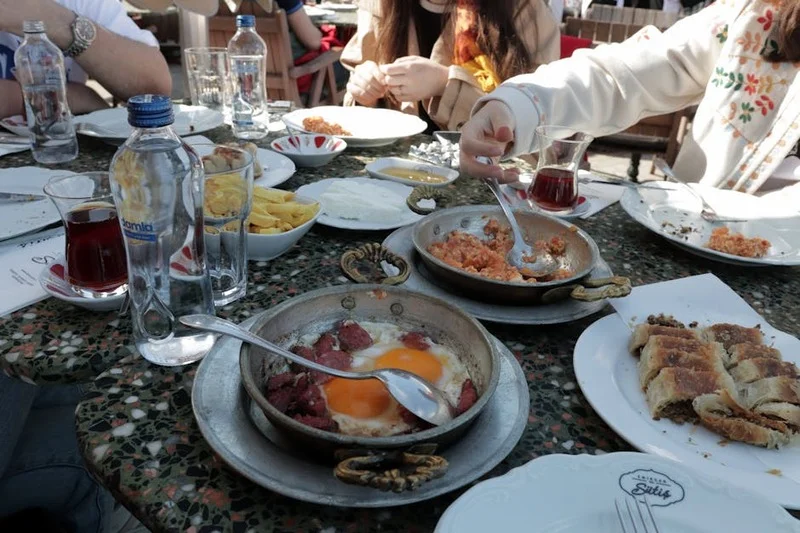 İstanbul'da güneşli bir günde canlı bir açık hava brunch'ının tadını çıkaran insanlar