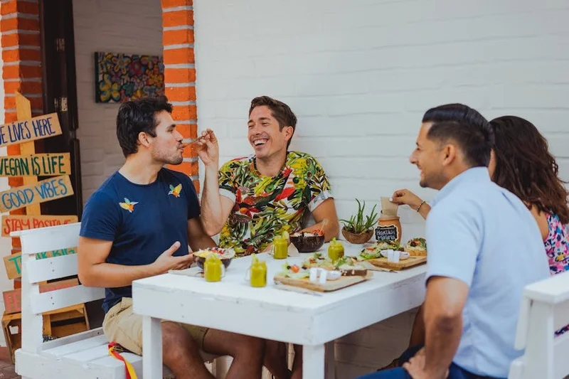 Çeşitli renkli yemekleri deneyen, vegan bir restoranda yemek yiyen farklı arkadaş grubu